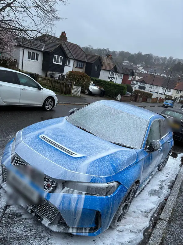 Blue Honda Civic Type R covered in snow foam on a residential street