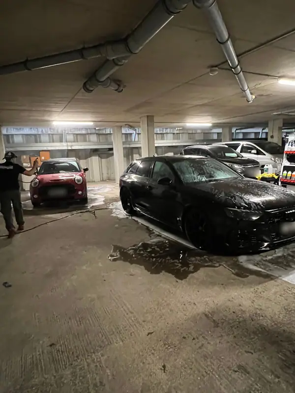 A Mini and an Audi RS being washed in an underground car park