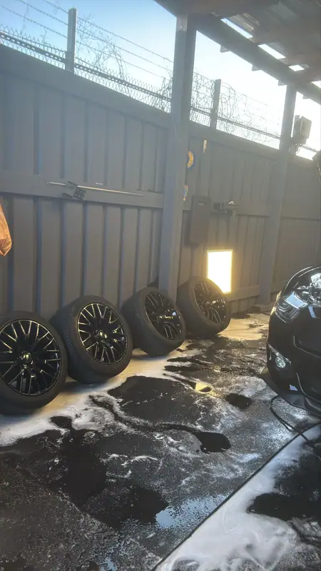 Ford Mustang wheels lined up against the studio wall while the car is worked on