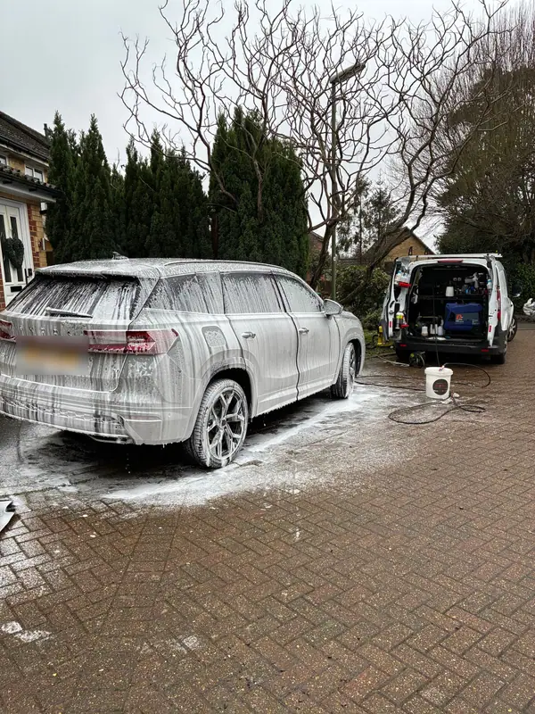 Large Skoda SUV in snow foam on a driveway with the OMVA van beside it